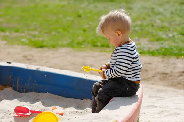 Criança menino no playground sandbox — Fotografia de Stock