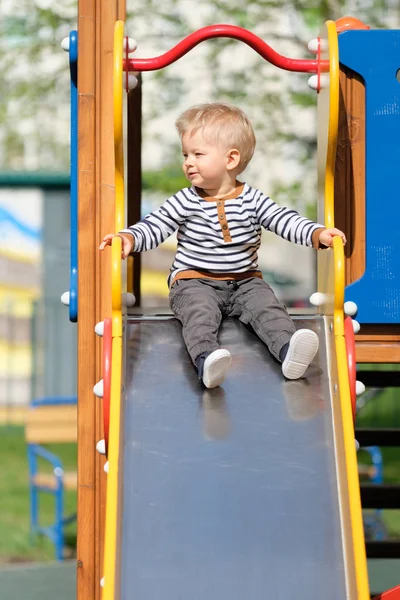 Menino da criança no diapositivo do playground — Fotografia de Stock