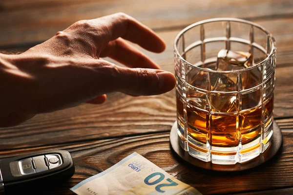 Mano maschile che raggiunge il bicchiere di whisky — Foto Stock