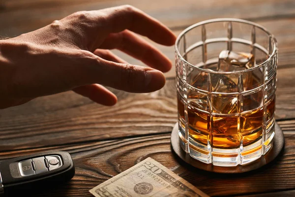 Mano maschile che raggiunge il bicchiere di whisky — Foto Stock