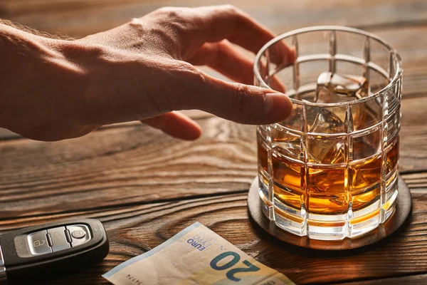 Mano maschile che raggiunge il bicchiere di whisky — Foto Stock