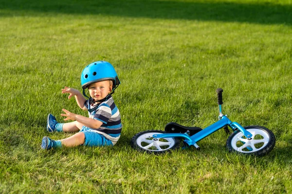 草の上に座ってヘルメットの少年 — ストック写真