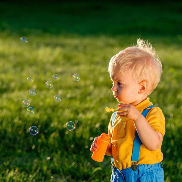 Хлопчик дме мильні бульбашки — стокове фото