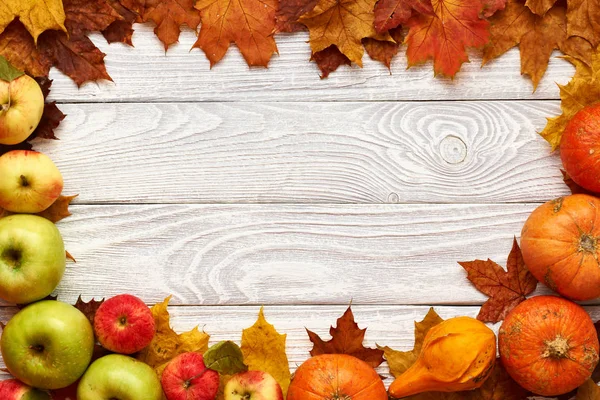 Feuilles d'automne, pommes et citrouilles sur fond de bois — Photo