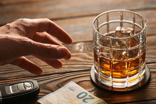 Mano maschile raggiungere per il vetro con whisky — Foto Stock