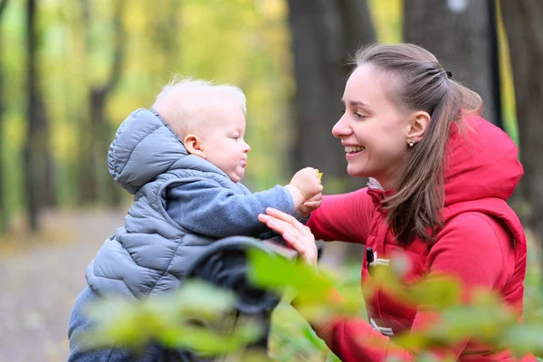 Junge im Herbstpark mit Mutter — Stockfoto