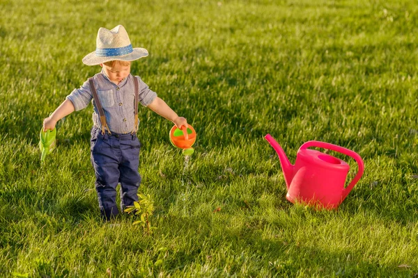 Baby boy using watering can — Stock Photo, Image