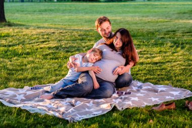 Üç parkta oturan mutlu aile