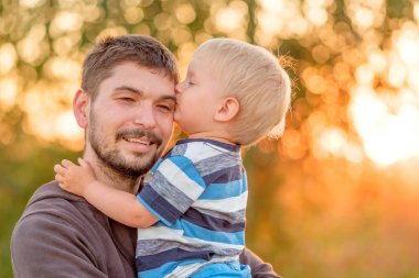 Adam holding çocuk ellerinde