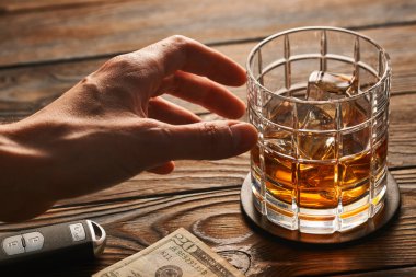 Alkol ve araba anahtarına ulaşan el 