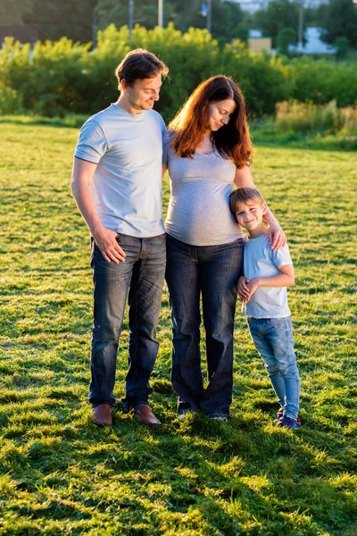 Família feliz de três em pé no parque — Fotografia de Stock