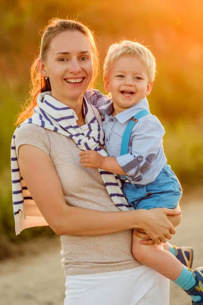 Kvinna anläggning barn på händer — Stockfoto