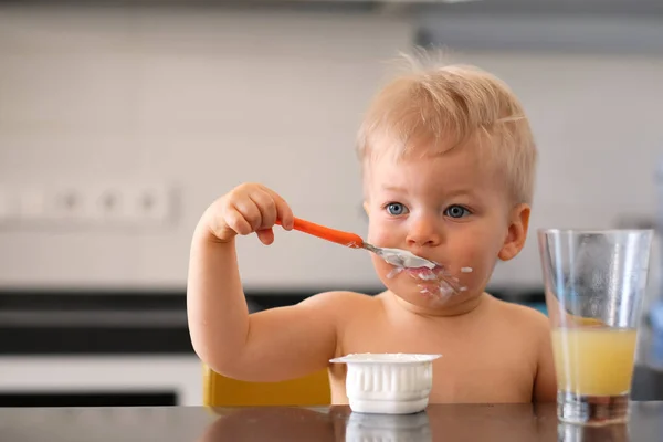 Um ano de idade menino comendo iogurte — Fotografia de Stock