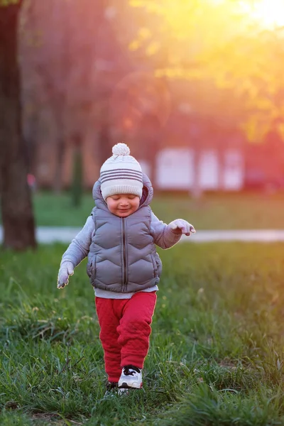 Niño en el prado del parque durante el atardecer —  Fotos de Stock