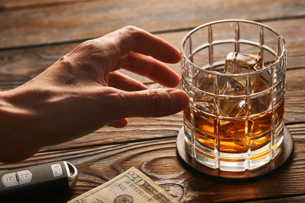 Alkol ve araba anahtarına ulaşan el 