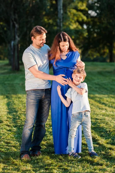 Família feliz de três em pé no parque — Fotografia de Stock