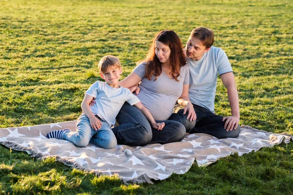 Zwangere gezin van drie in park — Stockfoto