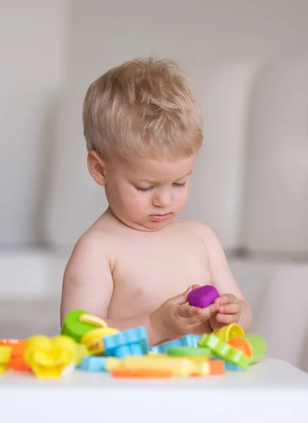 Jongen spelen met kleurrijke boetseerklei — Stockfoto