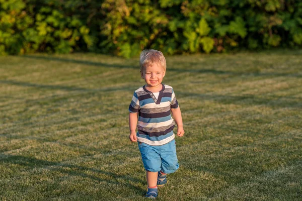 Babyjongen uitgevoerd op weide — Stockfoto