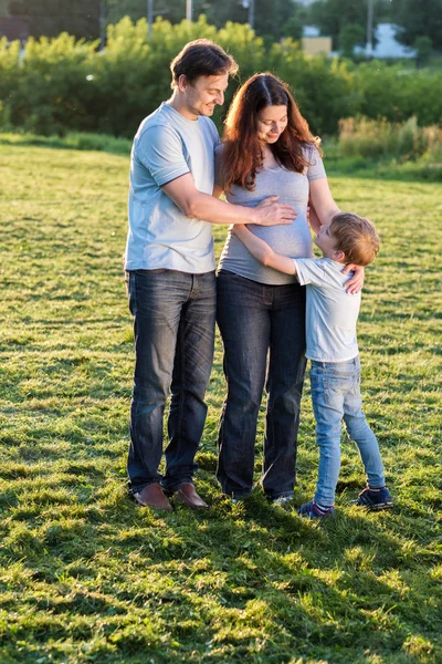 Familia feliz de tres de pie en el parque —  Fotos de Stock