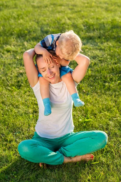 Mãe e criança se divertindo na grama — Fotografia de Stock