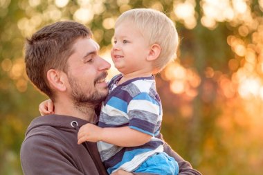 Adam holding çocuk ellerinde