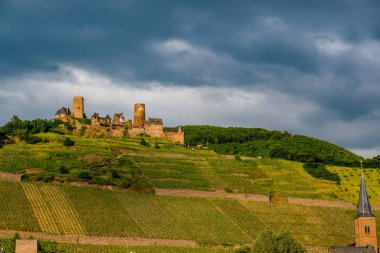 Thurant Kalesi ve üzüm bağları Moselle Nehri üzerinde ve dramatik gökyüzü altında Alken, Almanya yakın. 1198 1206 arasında inşa.