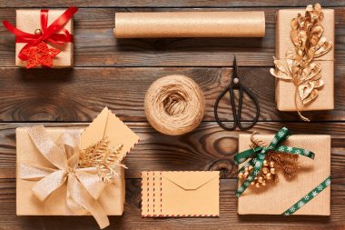 Ahşap arka plan kutularındaki yaratıcı bir şekilde sarılmış ve dekore edilmiş Noel hediyeleri. Üstten Görünüm yukarıdan. Düz yatıyordu. 