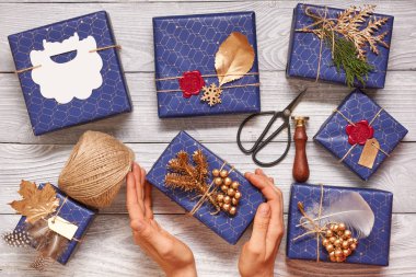 Noel hediyeleri kaydırma kadın. Ahşap arka plan kutularındaki yaratıcı bir şekilde sarılmış ve dekore edilmiş Noel hediyeleri. Üstten Üstten Görünüm. 