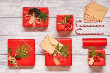 Beyaz ahşap zemin üzerinde kutularındaki yaratıcı bir şekilde sarılmış ve dekore edilmiş Noel hediyeleri. Üstten Görünüm yukarıdan. Düz yatıyordu. 