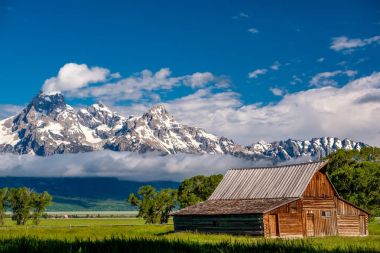 Alçak bulutlar ile eski mormon ahır Grand Teton Dağları'nda. Grand Teton Milli Parkı, Wyoming, ABD.