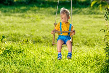 açık havada sallanan küçük sarışın çocuk portresi tam uzunlukta