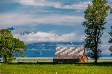 Alçak bulutlar ile eski mormon ahır Grand Teton Dağları'nda. Grand Teton Milli Parkı, Wyoming, ABD.