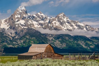 Alçak bulutlar ile eski mormon ahır Grand Teton Dağları'nda. Grand Teton Milli Parkı, Wyoming, ABD.
