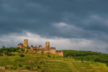 Thurant Kalesi ve üzüm bağları Moselle Nehri üzerinde ve dramatik gökyüzü altında Alken, Almanya yakın. 1198 1206 arasında inşa.