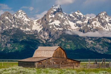 Alçak bulutlar ile eski mormon ahır Grand Teton Dağları'nda. Grand Teton Milli Parkı, Wyoming, ABD.