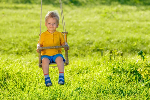 Volledige Lengte Portret Van Blond Jongetje Swingen Buitenshuis — Stockfoto