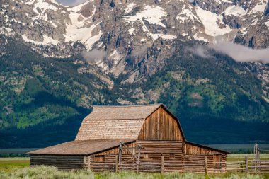 Alçak bulutlar ile eski mormon ahır Grand Teton Dağları'nda. Grand Teton Milli Parkı, Wyoming, ABD.