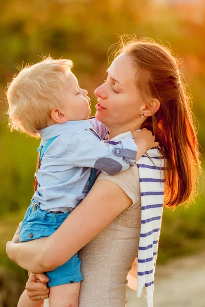 快乐的女人和孩子在户外玩耍 家庭生活在夕阳的阳光下 母亲和儿子的田园风光 男孩亲吻他的妈妈 — 图库照片