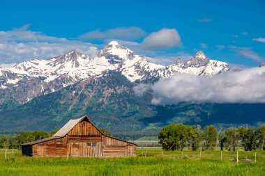 Alçak bulutlar ile eski mormon ahır Grand Teton Dağları'nda. Grand Teton Milli Parkı, Wyoming, ABD.