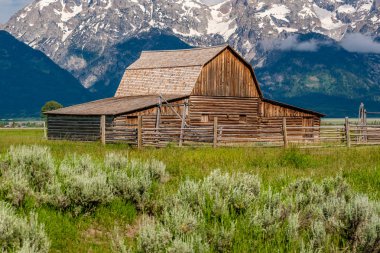 Alçak bulutlar ile eski mormon ahır Grand Teton Dağları'nda. Grand Teton Milli Parkı, Wyoming, ABD.