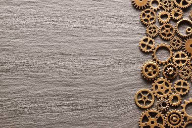 Çeşitli metal cogwheels ve arduvaz arka plan üzerinde dişli tekerler