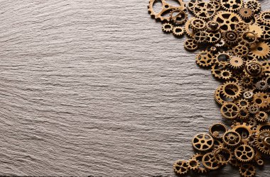 Çeşitli metal cogwheels ve arduvaz arka plan üzerinde dişli tekerler