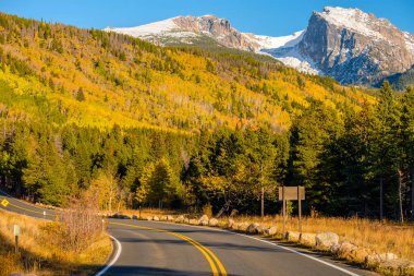 Rocky Dağı Ulusal Parkı 'nda sonbahar güneşli bir günde otoyol. Colorado, ABD. 