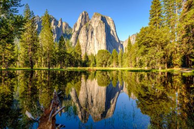 Middle Cathedral Rock reflecting in Merced River at Yosemite National Park. California, USA. clipart