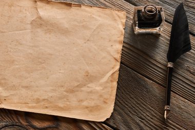 Tüy kalem ve ahşap arka plan üzerinde boş kağıt sayfası