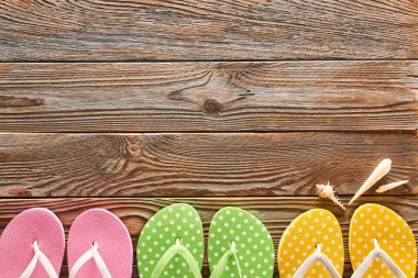 Ahşap arka plan üzerinde renkli parmak arası terlik