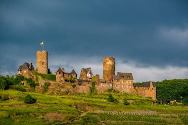 Thurant Kalesi ve üzüm bağları Moselle Nehri üzerinde ve dramatik gökyüzü altında Alken, Almanya yakın. 1198 1206 arasında inşa.