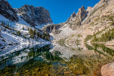 Zümrüt Gölü ve sonbaharda etrafındaki kayalar ve dağlarla yansıması. Colorado, ABD 'deki Rocky Dağı Ulusal Parkı