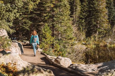 Kadın turist iz Bear Lake yakınındaki sonbahar Rocky Mountain milli parkta yürürken. Colorado, ABD. 